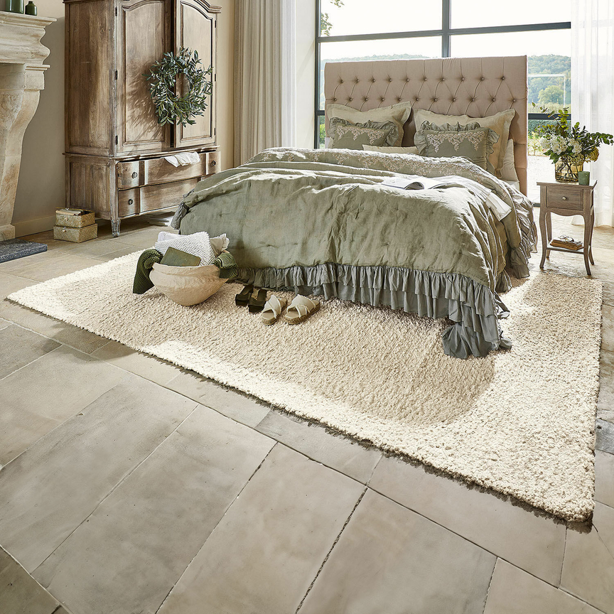 Gemütliches Schlafzimmer mit beigem Teppich und grünem Leinenbettwäsche-Set im rustikalen Stil
